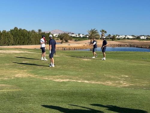 a group of people playing golf on a golf course at Pickalbatros Golf Luxury Suites - All Inclusive in Sharm El Sheikh