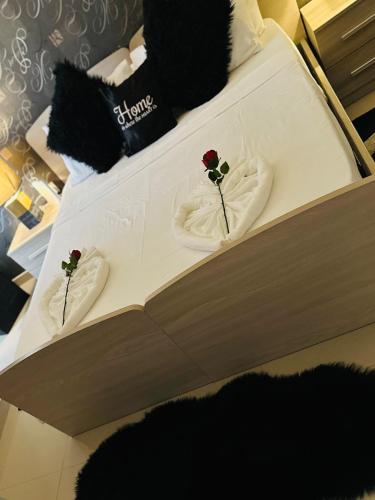 a bed with two roses on top of it at Couple's Getaway in Is-Swieqi
