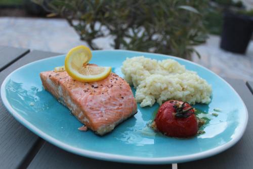 a blue plate with salmon and rice and a tomato at Villa Marie in Courçon