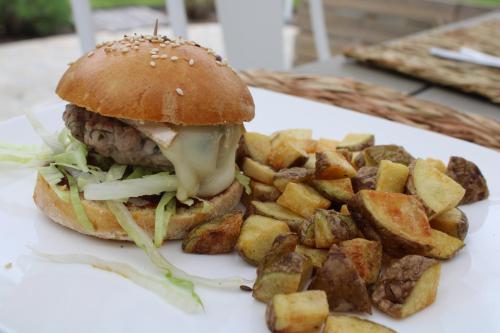 a sandwich and some potatoes on a white plate at Villa Marie in Courçon