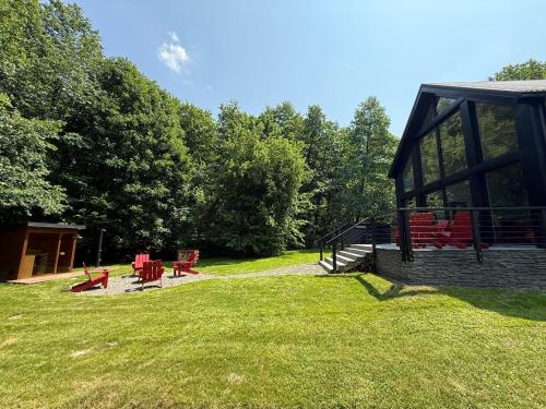a group of red chairs sitting on a grass field at Mátramélye Vendégház in Parád
