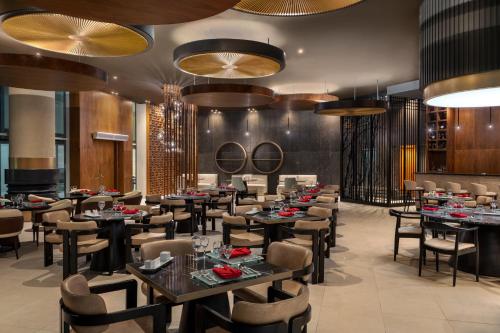 a dining room with tables and chairs and chandeliers at Pickalbatros Golf Luxury Suites - All Inclusive in Sharm El Sheikh