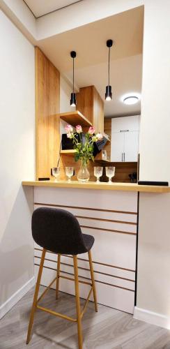 a chair at a kitchen counter with a vase of flowers at Bamboo Beach Tsikhisdziri 347K in Tsikhisdziri