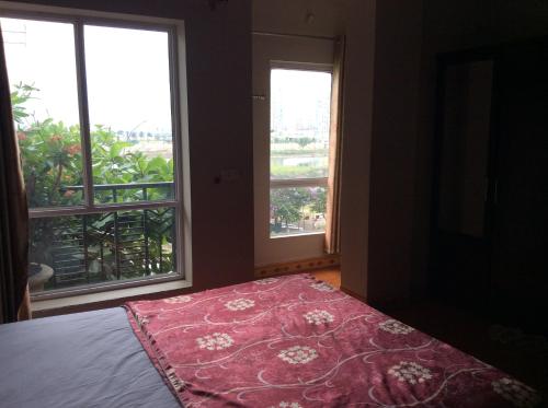a bedroom with two windows and a bed with a red rug at Hai Duong Hotel in Hòa Bình
