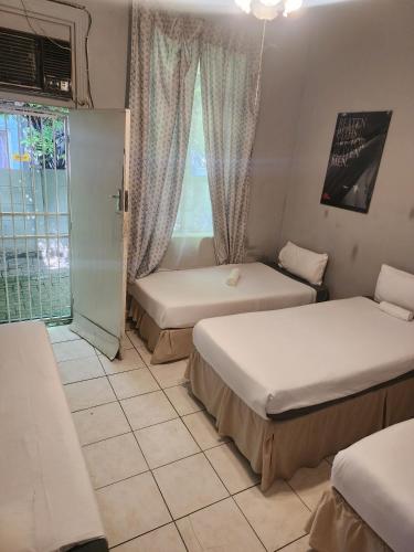 a hotel room with two beds and a window at Kudu Backpackers in Bloemfontein