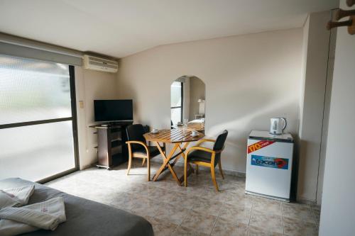 a living room with a table and chairs in a room at Patio Mediterraneo Apart Hotel in San Rafael