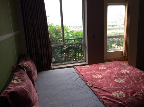 a bedroom with a bed and a large window at Hai Duong Hotel in Hòa Bình