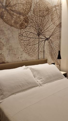 a bedroom with a white bed with a painting on the wall at Hotel La Rocca in San Marino