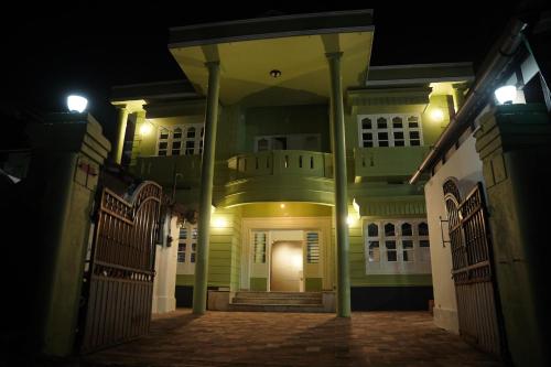 une maison vide la nuit avec un portail dans l'établissement Dormer Stay, à Kozhikode