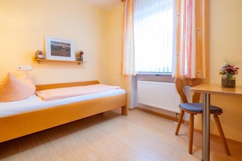 a small room with a bed and a desk and a window at Gasthof Geier in Wörth an der Donau