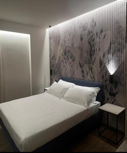 a bed with white sheets and pillows in a room at Hotel La Rocca in San Marino