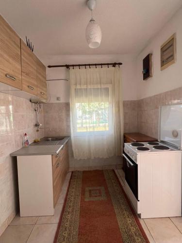 a small kitchen with a stove and a window at Haus Binas in Ulcinj