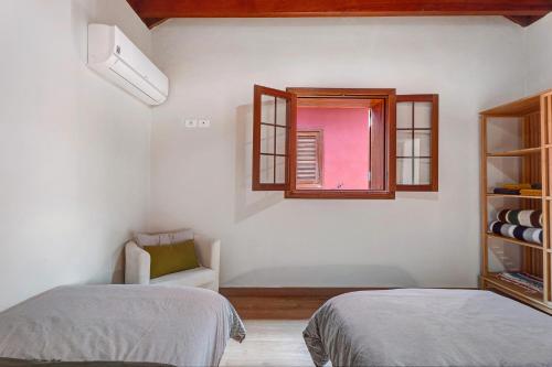 a white room with two beds and a window at Complejo Rural Pajar de Bento in Agulo