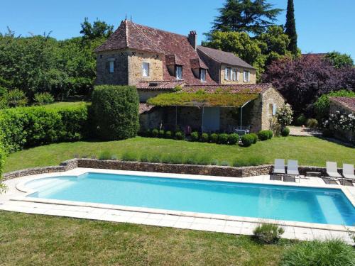 un domaine avec une piscine devant une maison dans l'établissement Maison de campagne avec piscine privée et parking à Sainte Alvère - FR-1-824-4, à Lentignac