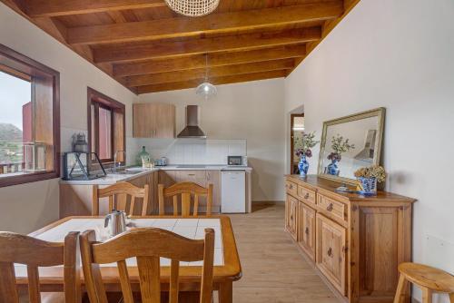 a kitchen with a table and a dining room at Complejo Rural Pajar de Bento in Agulo