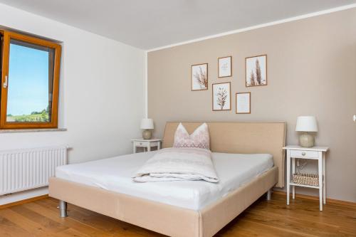 a white bedroom with a bed with pink pillows at Ferienwohnung Auf Dem Haldershof in Wangen im Allgäu