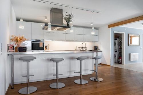 a kitchen with a counter and bar stools at Ferienwohnung Auf Dem Haldershof in Wangen im Allgäu