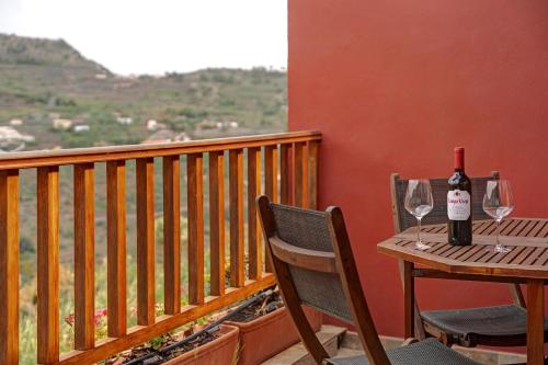 a table with two glasses of wine on a balcony at Complejo Rural Pajar de Bento in Agulo