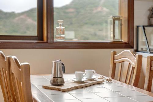 a table with two coffee cups and a kettle on it at Complejo Rural Pajar de Bento in Agulo