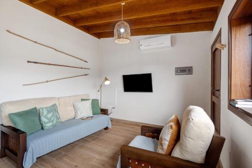 a living room with a couch and a tv at Complejo Rural Pajar de Bento in Agulo