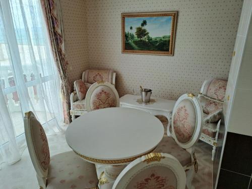 a dining room with a white table and chairs at Апартамент в КК "Елените" с фронтална гледка море, разположен на самия плаж in Sveti Vlas
