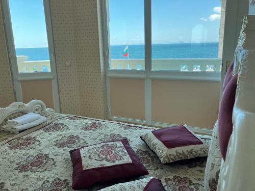 a bedroom with a bed with a view of the ocean at Апартамент в КК "Елените" с фронтална гледка море, разположен на самия плаж in Sveti Vlas
