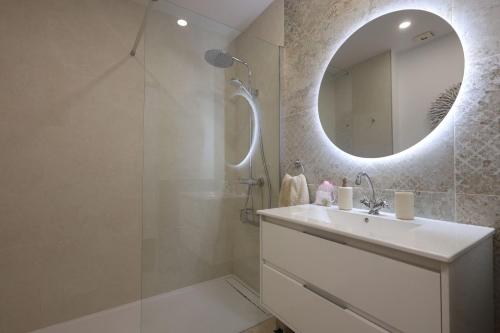 une salle de bain blanche avec un lavabo et un miroir dans l'établissement Apartamento Sebastian, à Adeje