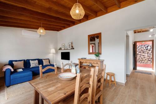 a living room with a blue couch and a wooden table at Complejo Rural Pajar de Bento in Agulo