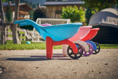 three plastic toy shopping carts sitting on the ground at Boutique House happYellow Saalbach, inkl JokerCard in Saalbach Hinterglemm