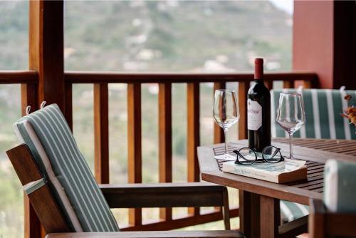a wooden table with two glasses and a bottle of wine at Complejo Rural Pajar de Bento in Agulo