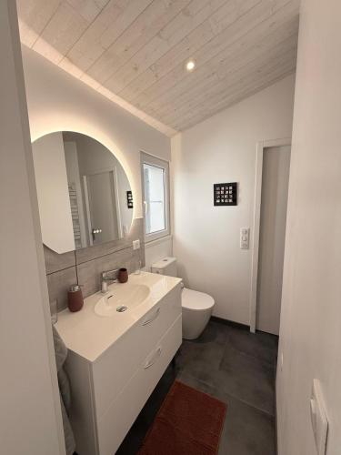une salle de bain blanche avec un lavabo et des toilettes dans l'établissement Maison de charme First d'Aromm - Plages, centre ville, phare de Chassiron - Calme, jardin clos, terrasse, à Saint-Denis-dʼOléron