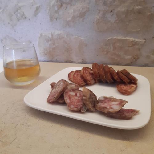 a plate of meat and bacon next to a glass of beer at Villa Marie in Courçon