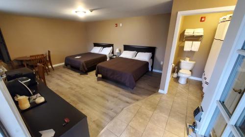 a hotel room with two beds and a toilet at Abbot Trailside Lodging in Abbot Village