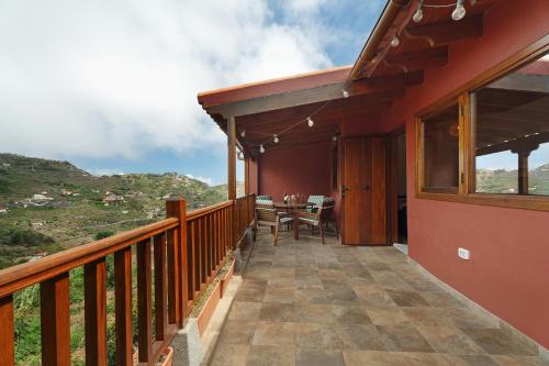 a balcony of a house with a table and chairs at Complejo Rural Pajar de Bento in Agulo