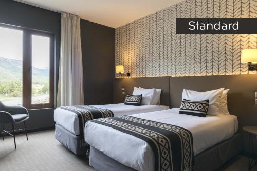 a hotel room with two beds and a window at Río Serrano Hotel + Spa in Torres del Paine