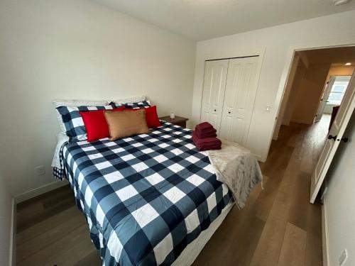 a bedroom with a blue and white bed with red pillows at Seton Villas Cozy Four-bed house in Calgary