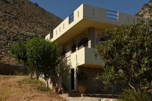 a house on a hill with trees in front of it at Artemisa House in Agia Roumeli