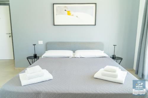 a bedroom with a bed with two towels on it at Villa Mediterranea Apartments - Seaview, Pool & Garden in Bari