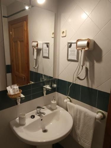 a bathroom with a sink and a mirror at Hostal Puerta Medina in Sigüenza