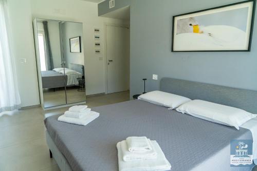a bedroom with a bed with two towels on it at Villa Mediterranea Apartments - Seaview, Pool & Garden in Bari