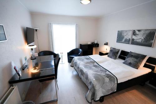 a bedroom with a bed and a desk with a desk at Golf Hotel Viborg in Viborg