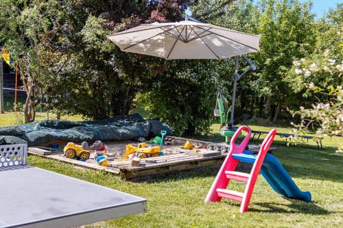 a play area with a sandbox and an umbrella at Ferienwohnung Auf Dem Haldershof in Wangen im Allgäu