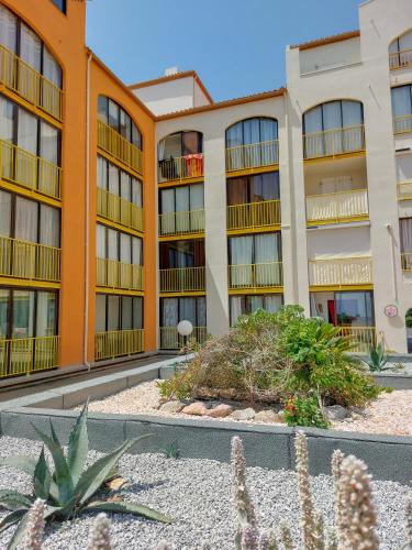 an apartment building with plants in front of it at Appart avec loggia en front de mer et superbe vue in Le Barcarès