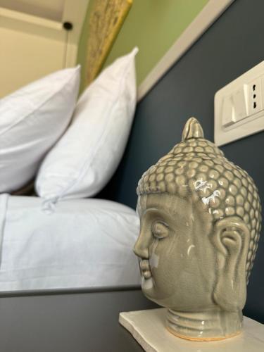 a statue of a head on a shelf next to a bed at Casa Teresa Guest Rooms in Parghelia