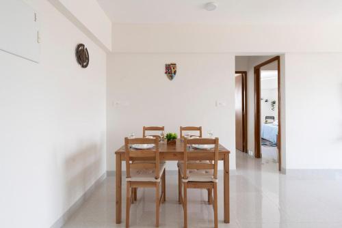 une salle à manger avec une table et des chaises en bois dans l'établissement Breezy, Bright, Upper Floor 2bhk nr BKC & Airport, à Mumbai