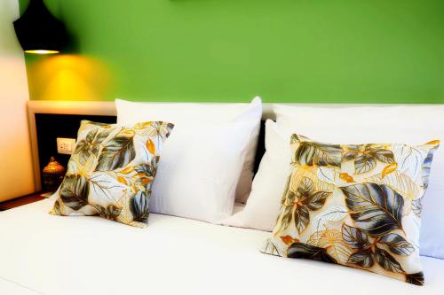 a bed with white pillows and a green wall at Casa Teresa Guest Rooms in Parghelia