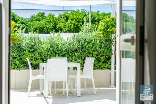 a white table and chairs on a patio at Villa Mediterranea Apartments - Seaview, Pool & Garden in Bari