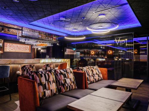 a bar with chairs and tables and purple lighting at Hotel Bania Thermal & Ski in Białka Tatrzanska