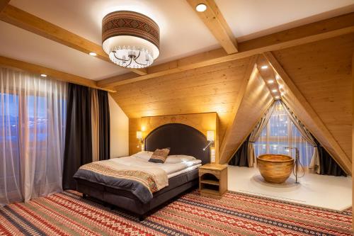 a bedroom with a bed and a chandelier at Hotel Bania Thermal & Ski in Białka Tatrzanska