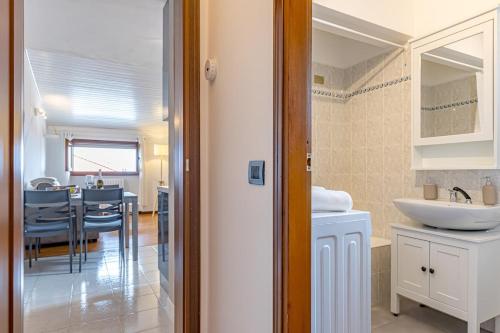 a white bathroom with a sink and a table at ROMANTIC COMO HIDEAWAY with private parking and AirCon in Acquaseria